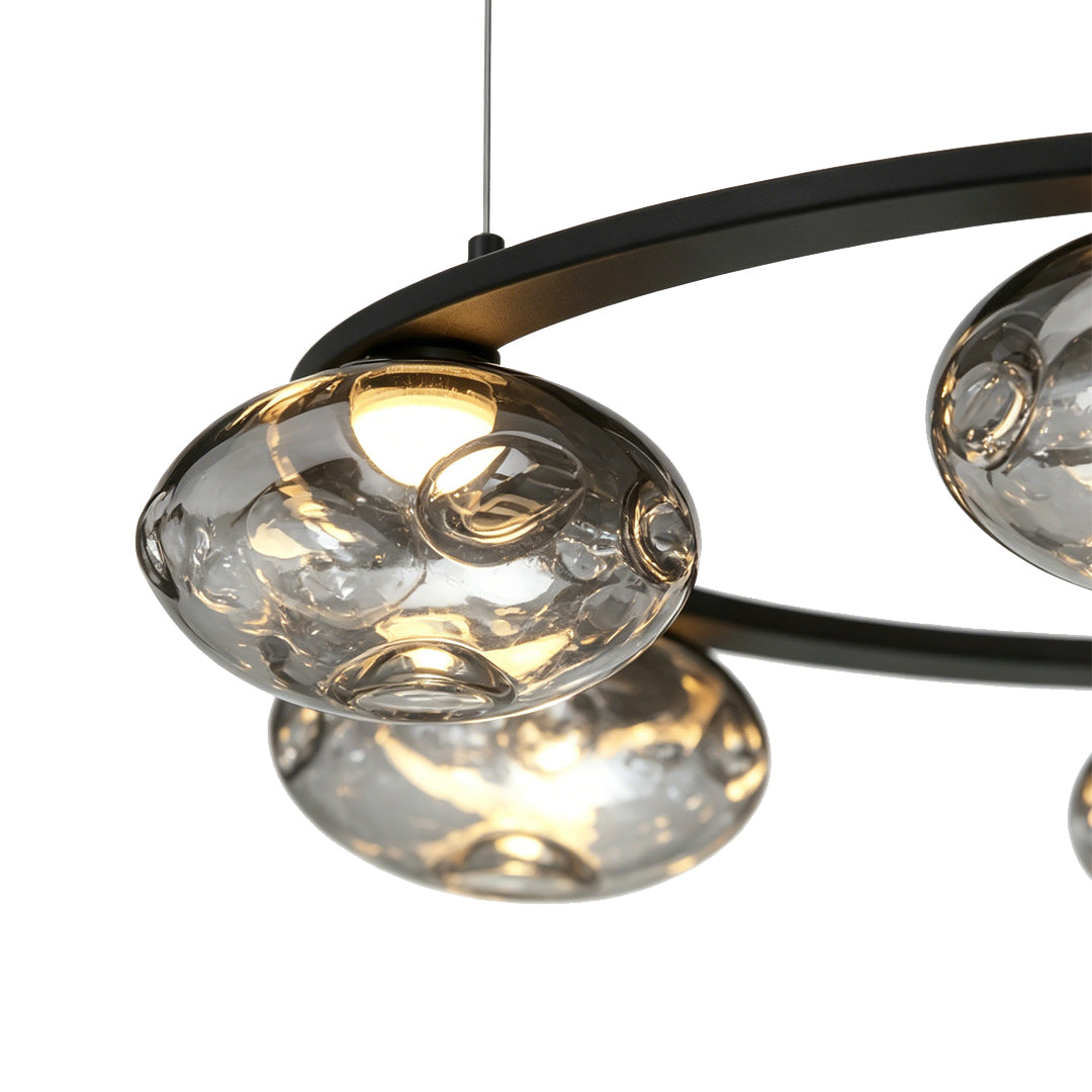 Detailed view of curved black frame and glass lights on modern traditional chandelier.