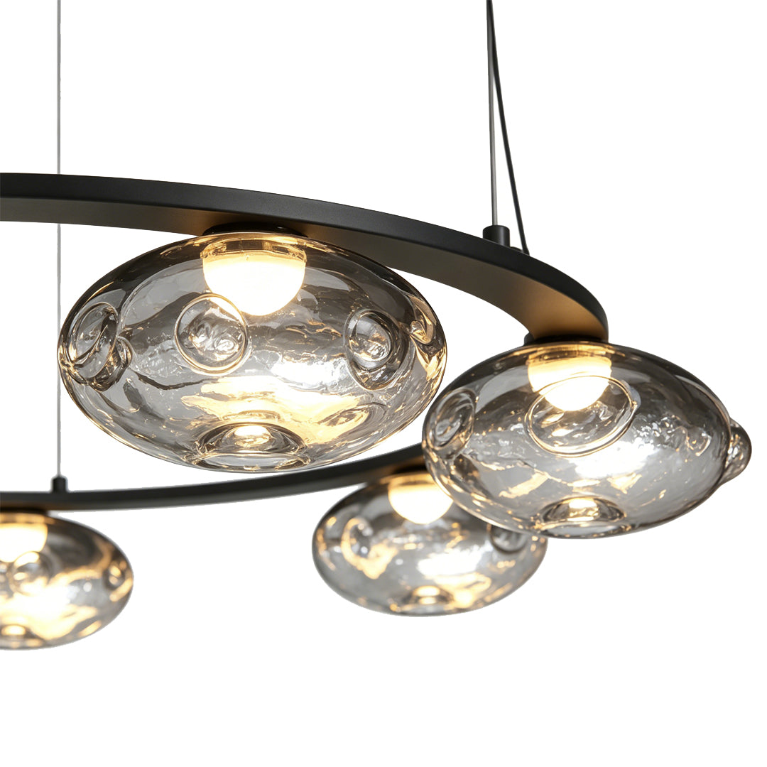 Close-up of glass shades on a modern traditional chandelier with warm lighting.