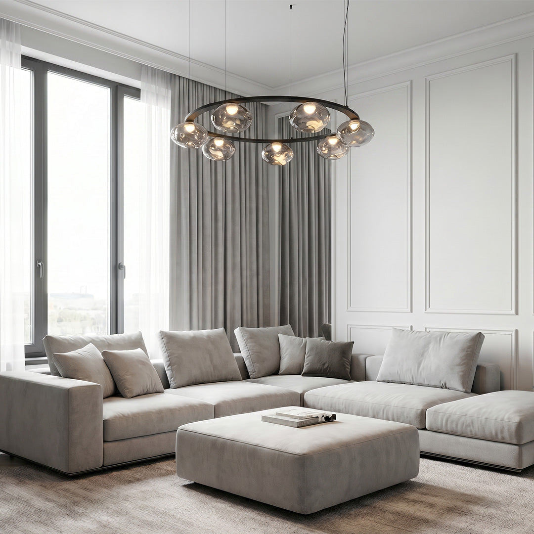 Modern traditional chandelier in a bright living room with large windows.