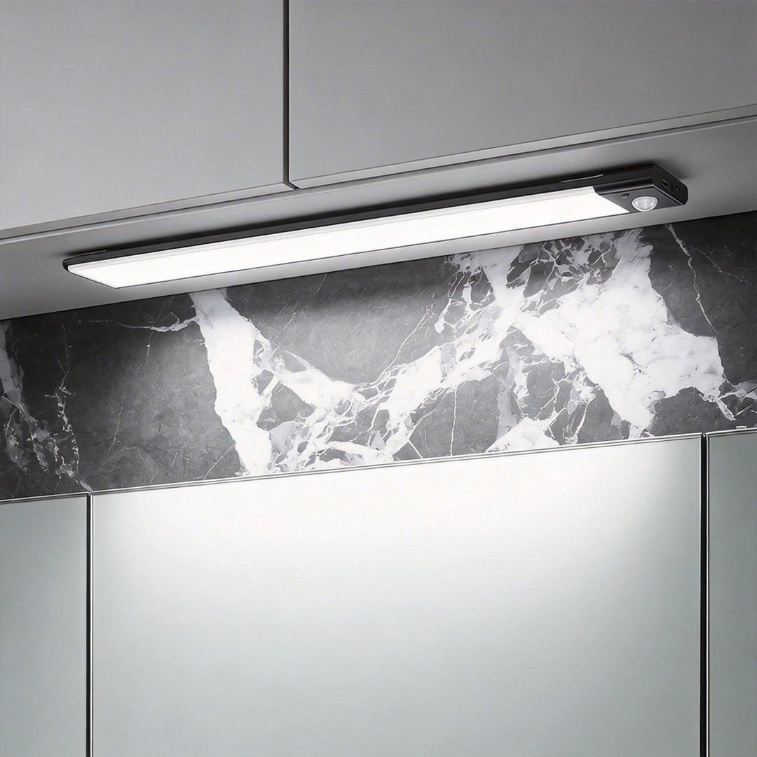 Modern under cabinet sensor light mounted above a beautiful grey marble kitchen backsplash ok.