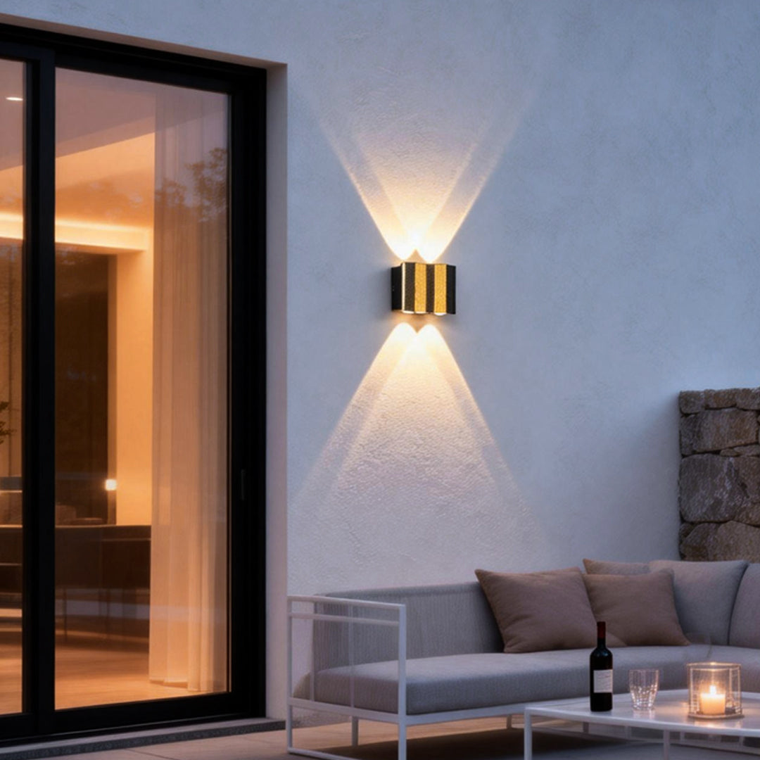 Modern up and down wall lights mounted on a contemporary exterior patio wall, casting warm symmetrical beams to enhance outdoor seating areas.