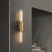 Modern up down wall lights with gold finish, casting warm illumination in a contemporary indoor setting.