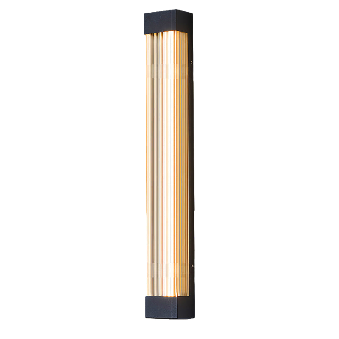 Modern vertical linear outdoor sconce featuring a warm, gold-tinted ribbed diffuser and black frame.