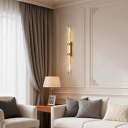 Modern vertical tube wall sconce installed beside a sofa in a living room.