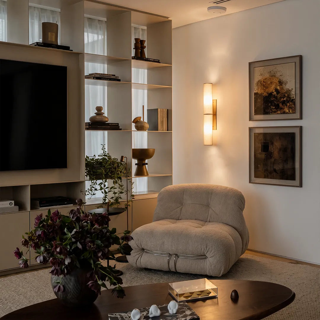 Modern vertical wall sconce adding warm accent lighting to a contemporary living room wall.