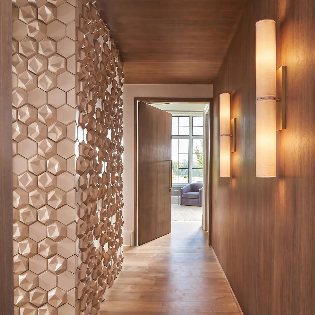 Modern vertical wall sconce arranged in a hallway with warm ambient lighting and textured wall panels.