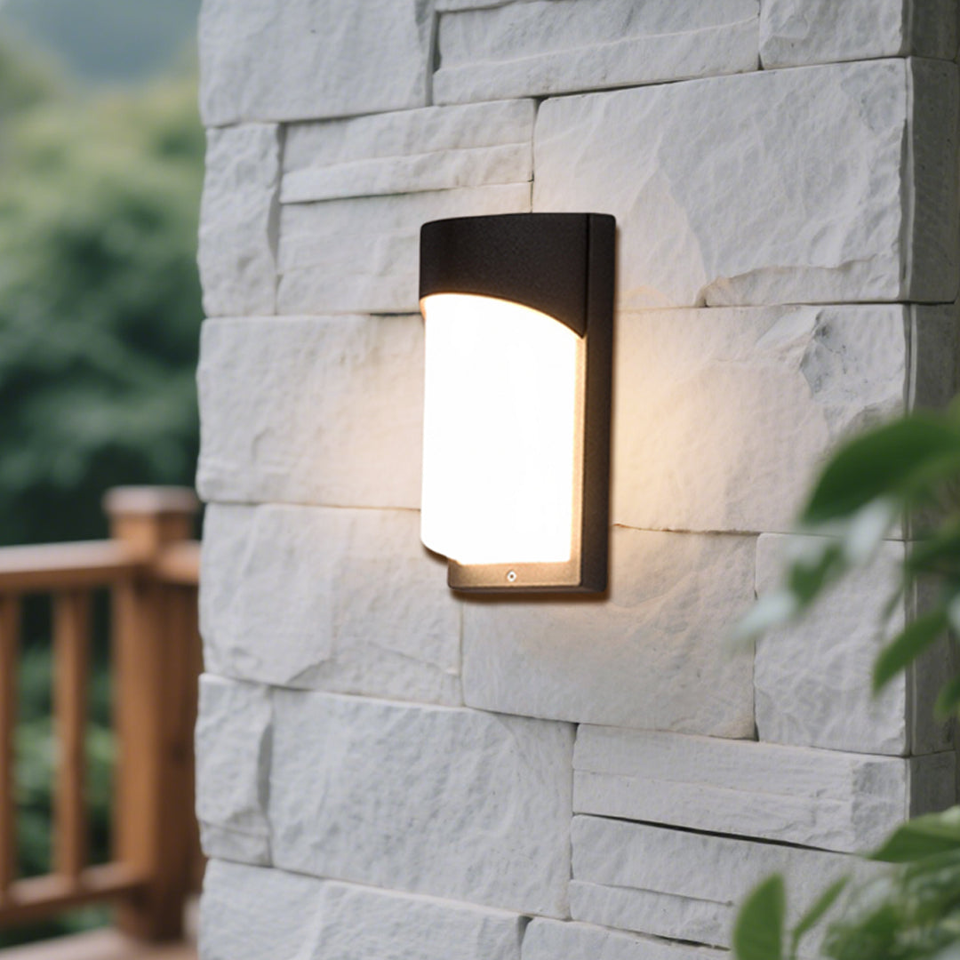 Modern wall light fixture installed on natural stone surface with warm LED glow and sleek design