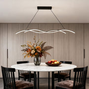 Modern wave LED pendant light suspended above a round dining table, creating a soft and elegant ambient glow.