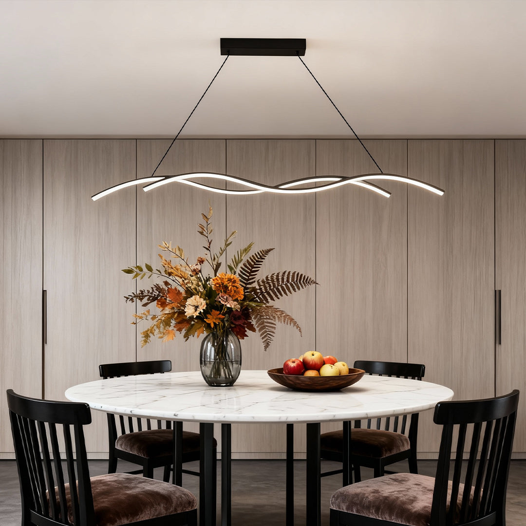 Modern wave LED pendant light suspended above a round dining table, creating a soft and elegant ambient glow.