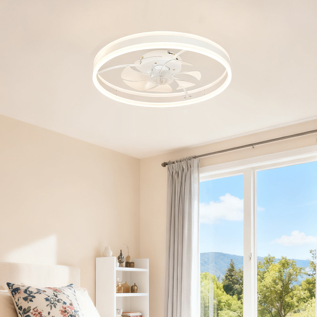 Modern white ceiling fan with light fixture providing illumination and airflow in a bright room with large windows overlooking a scenic view. 