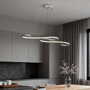 Modern white chandeliers with sleek curved design, hanging above a dining table in a contemporary kitchen.