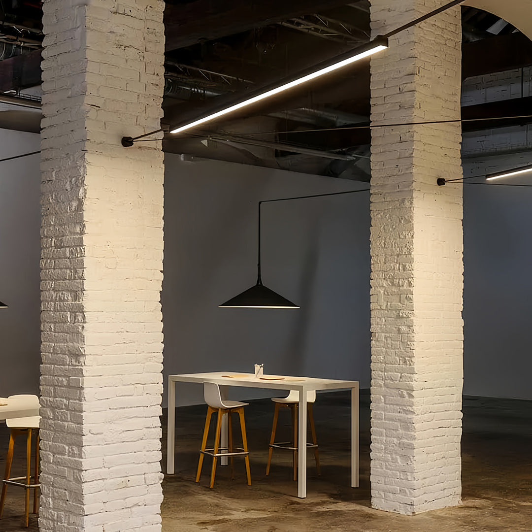 Modern workspace featuring long pendant light fixtures, stylish and functional linear lighting