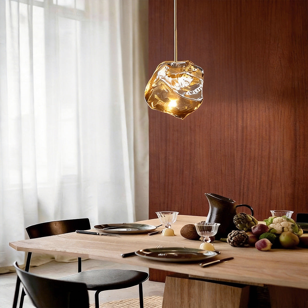 Molten rock pendant light illuminating a modern dining table with warm, golden glow.