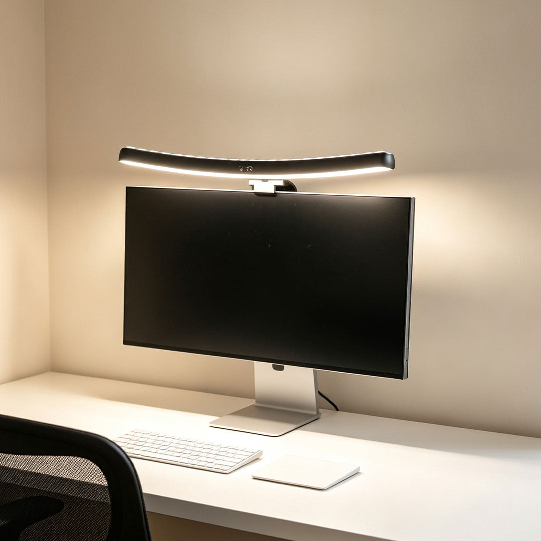 Monitor LED light bar illuminating a clean white desk setup with a widescreen computer monitor.