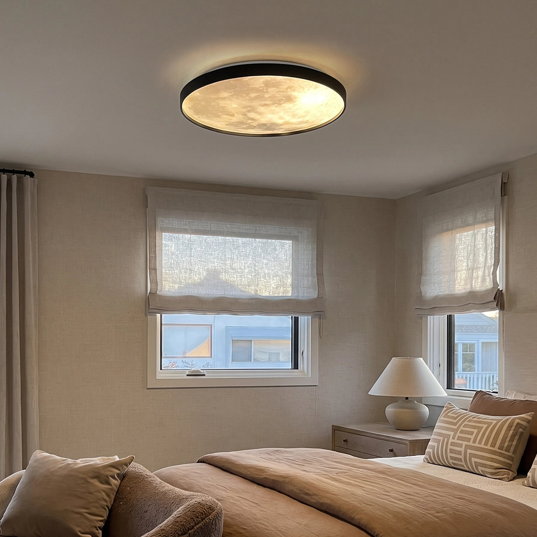 Moon ceiling light mounted on a bedroom ceiling, illuminating a soft neutral space with windows and bedside decor.