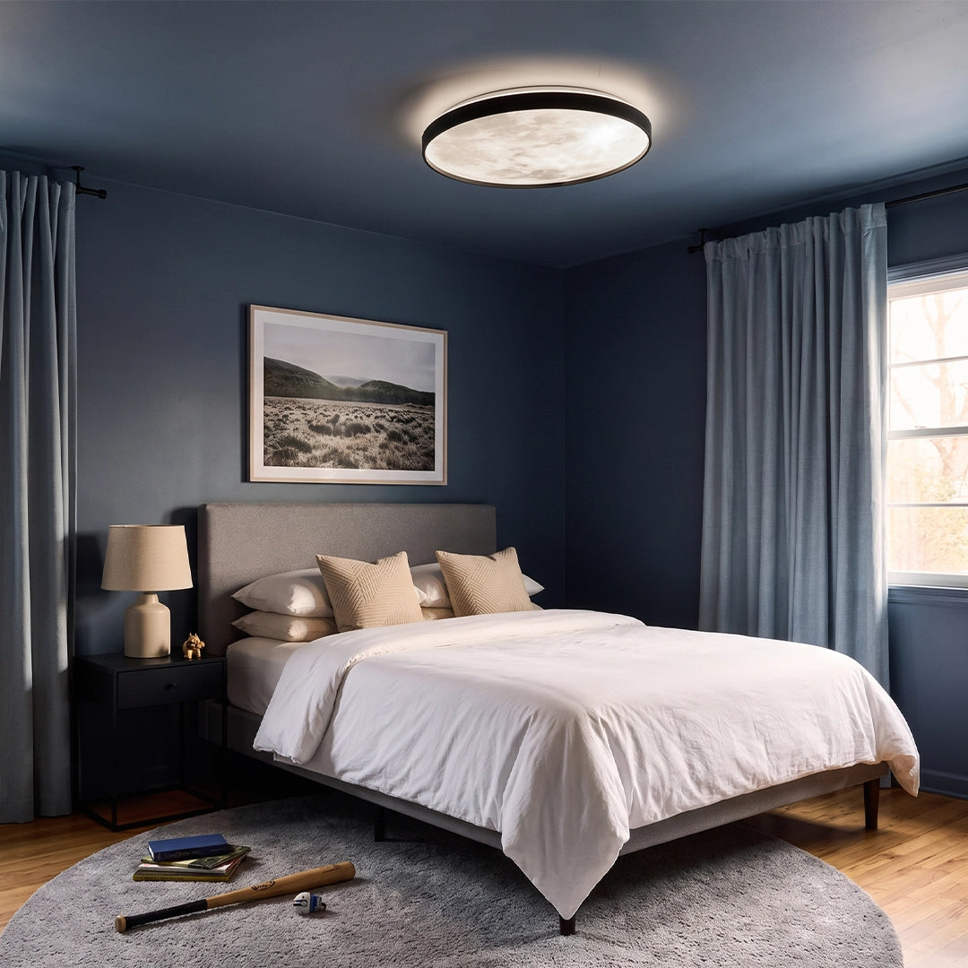Moon ceiling light illuminating a dark blue bedroom with a bed, curtains, and bedside tables.