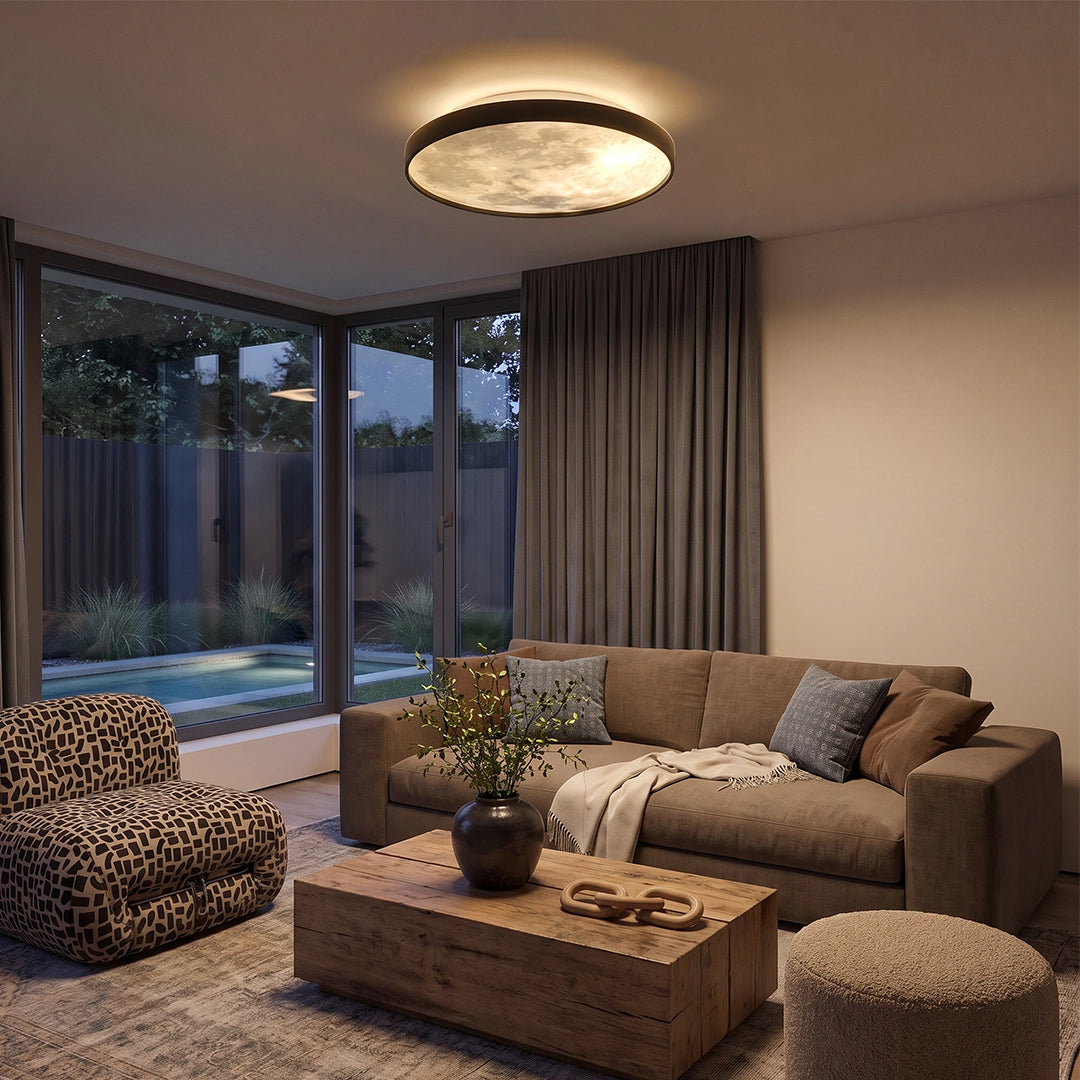 Moon ceiling light installed in a cozy living room with a sofa, large windows, and warm ambient lighting.