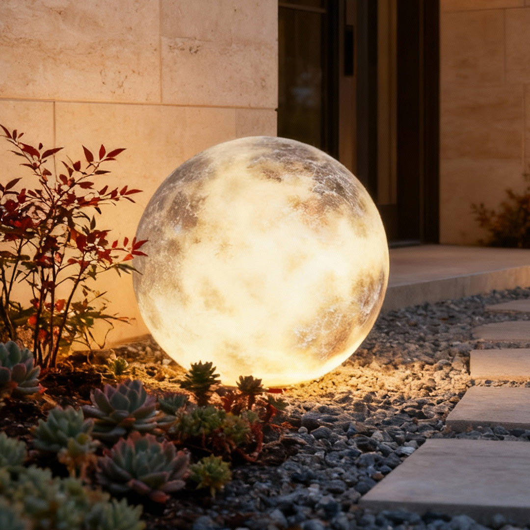 Moon light sphere resting on stone ground in a modern yard