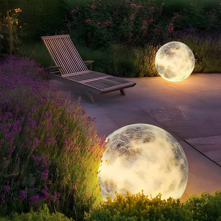 Moon light sphere beside patio lounge chairs in a garden