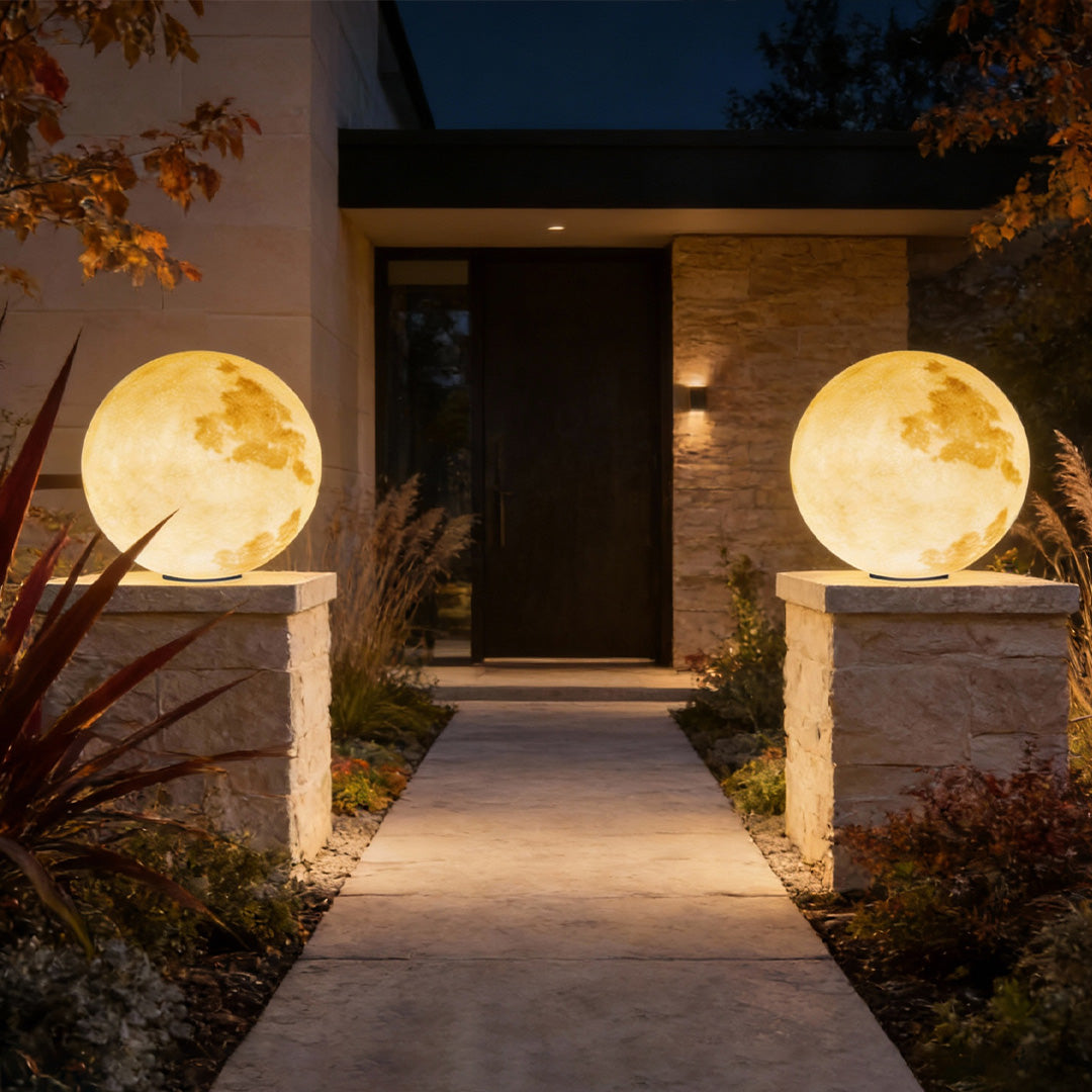 Moon-shaped stone pillar light illuminating entrance pathway with lush greenery.