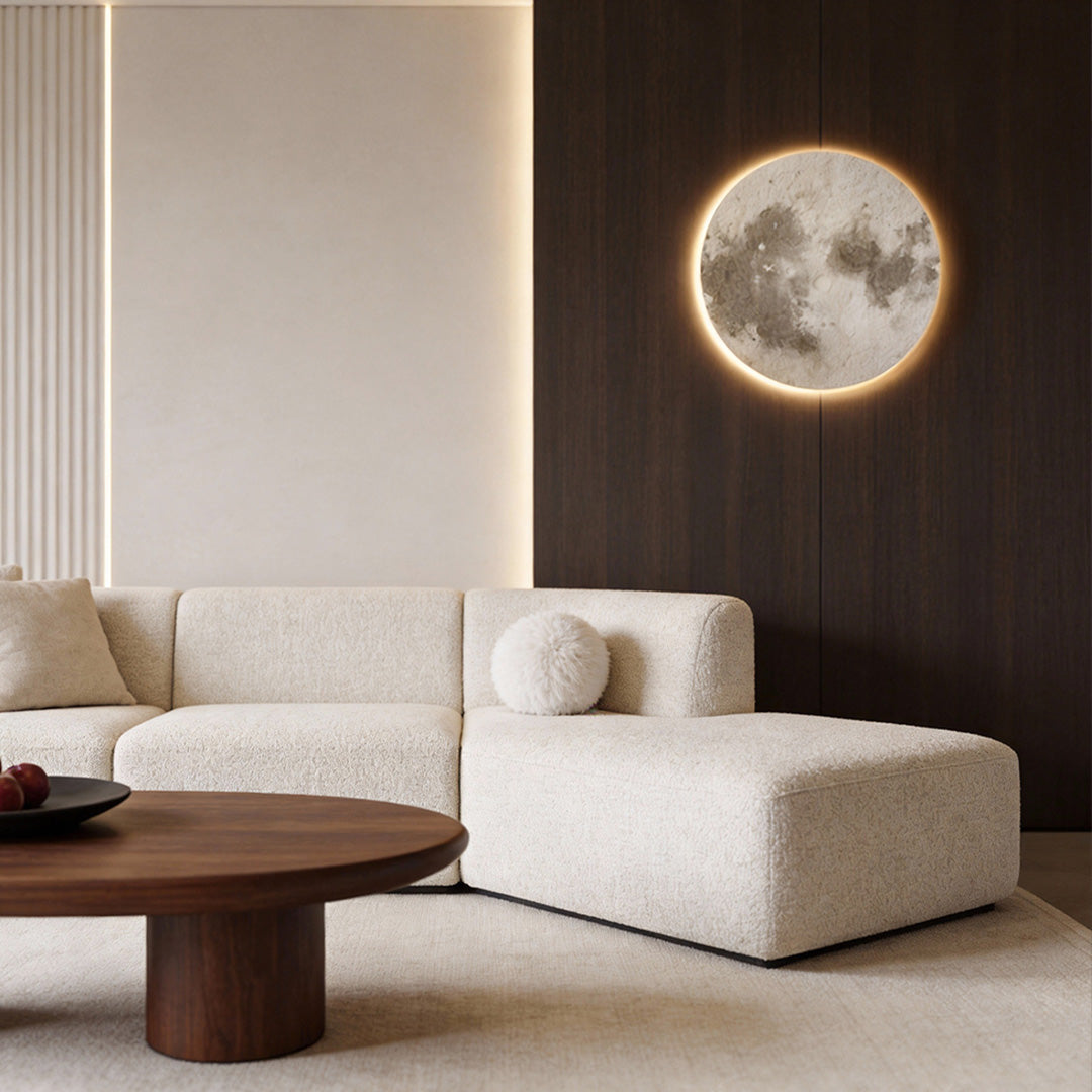 Moon wall lamp providing soft light above a modern sofa setup.