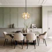 Elegant Moravian star pendant light hanging above a modern dining table with neutral decor.