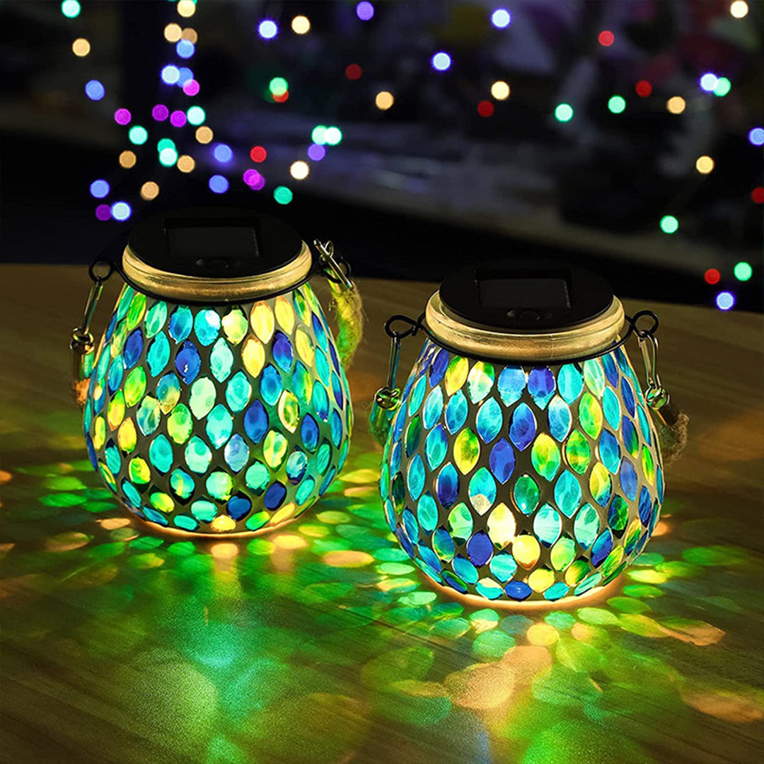 Collection of colorful mosaic solar lanterns on grass with autumn leaves decoration