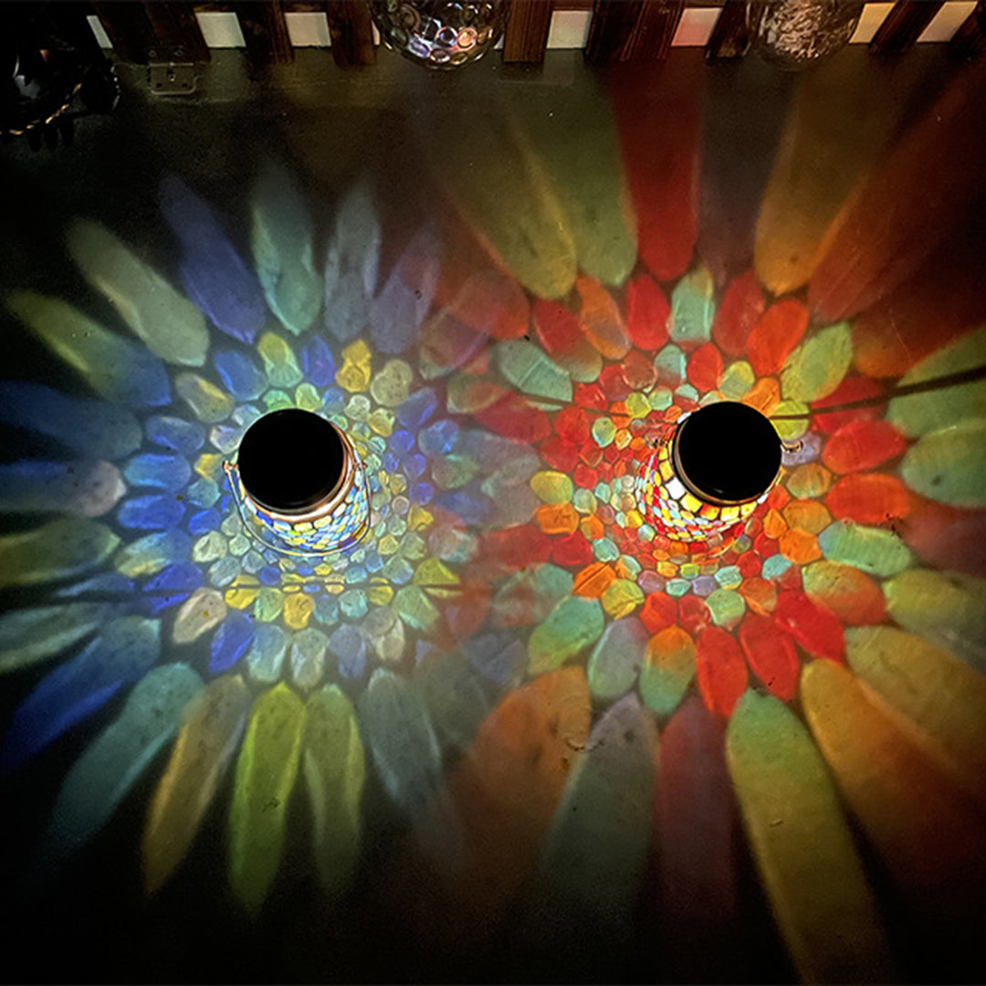 Two mosaic solar lanterns creating beautiful colorful light patterns on surface at night