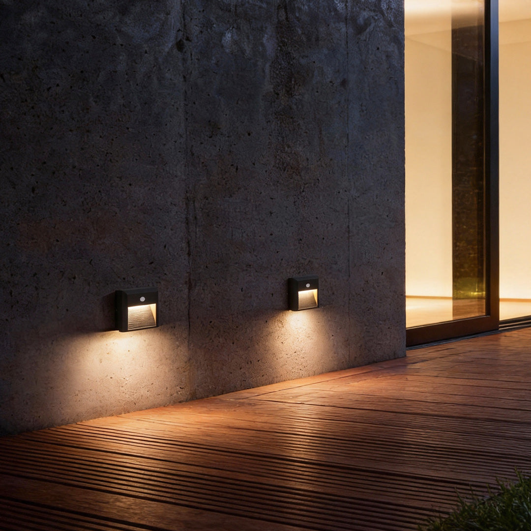 Motion sensor LED step lights providing soft illumination on a wooden deck.