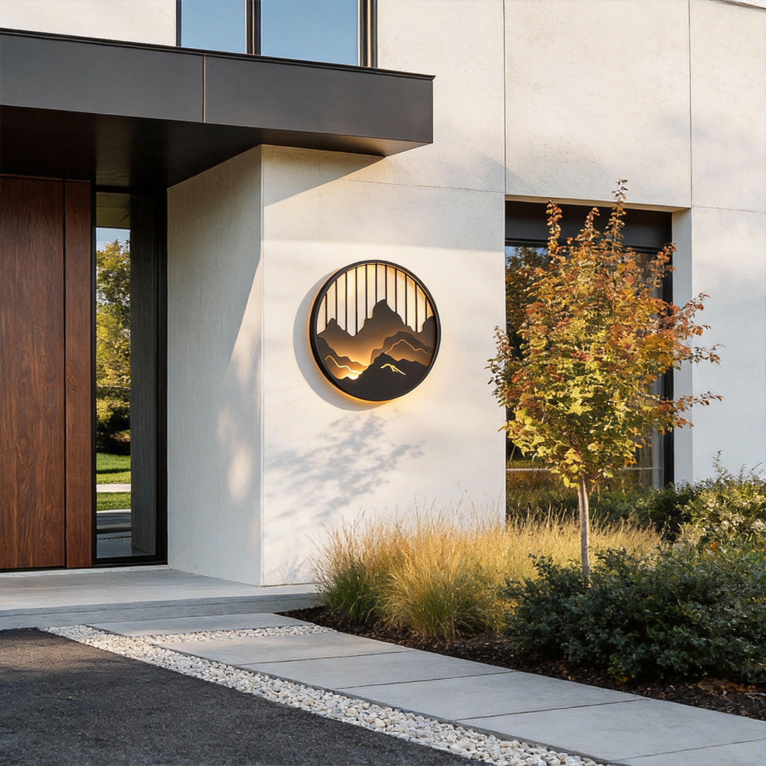 Round mountain LED wall light mounted near house entrance with warm ambient glow.