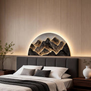 Mountain LED wall light adding a natural touch to a modern bedroom with a gray headboard.
