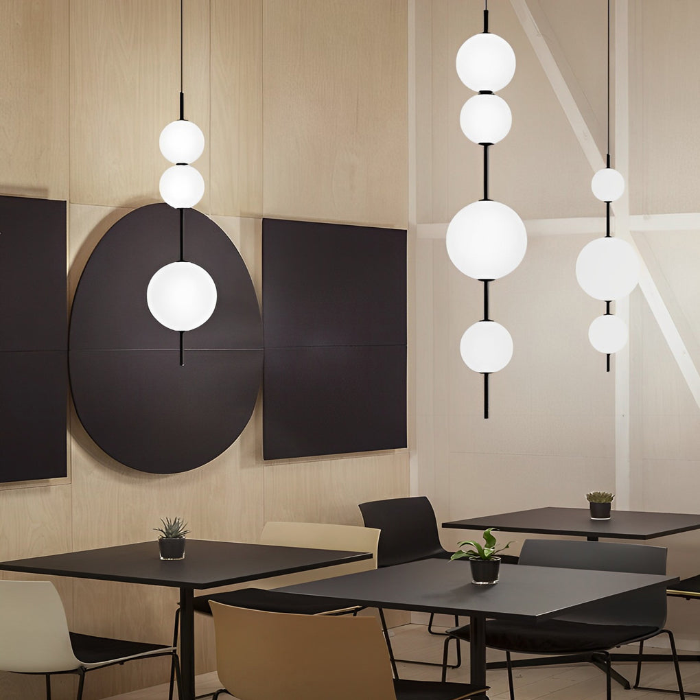 Multi ball pendant light with a sleek black and white design, enhancing a stylish dining area.