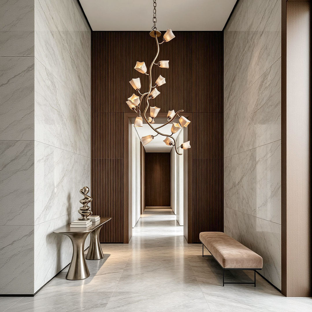 Multi light pendant chandelier installed in a tall hallway with stone walls and warm wood accents.