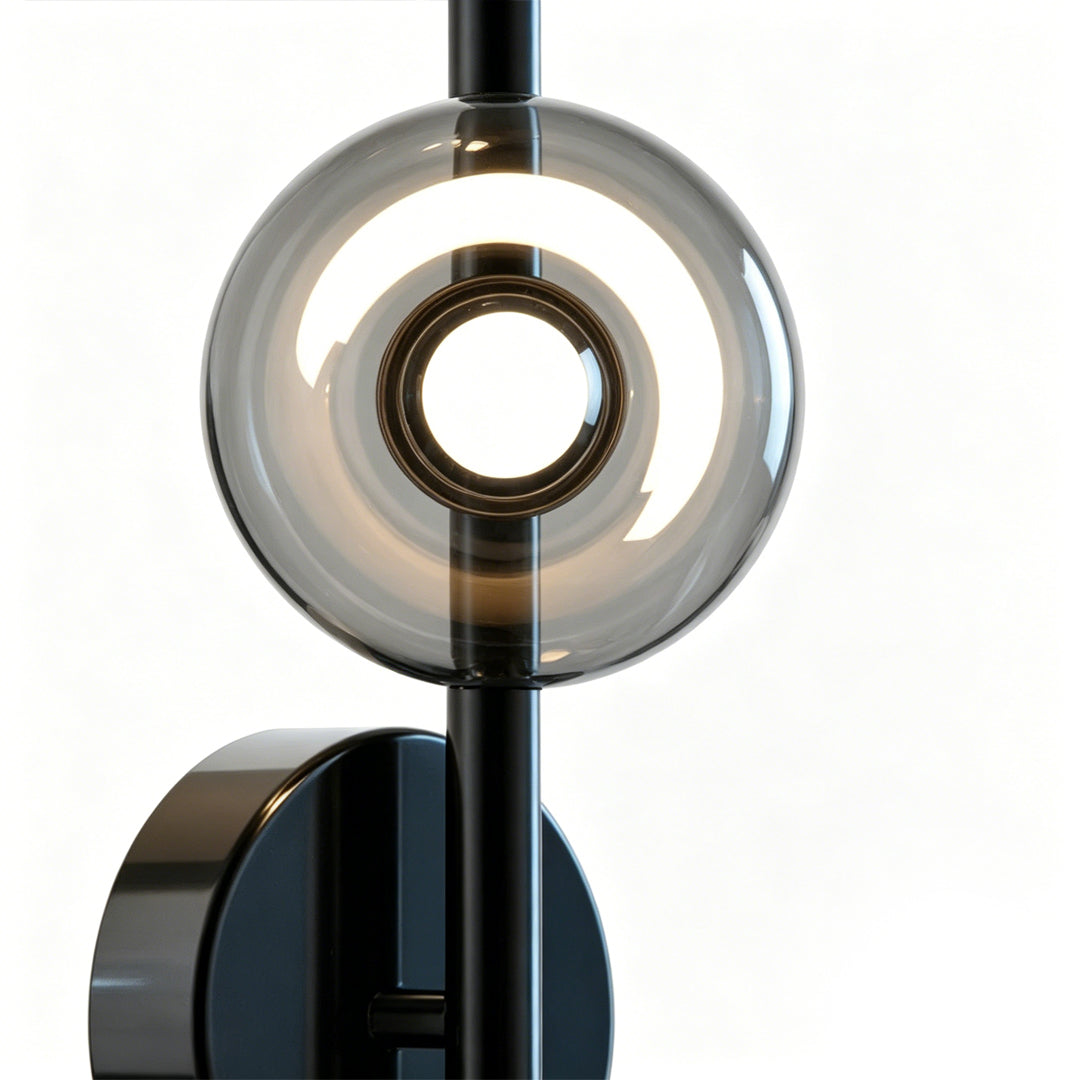 Close-up detail of multi light wall sconce with circular glass shade and LED ring lighting design.