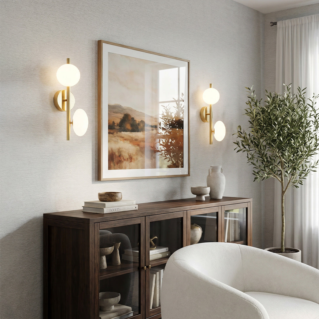 Multi light wall sconce installed above a sideboard in a living room with framed artwork and neutral decor.