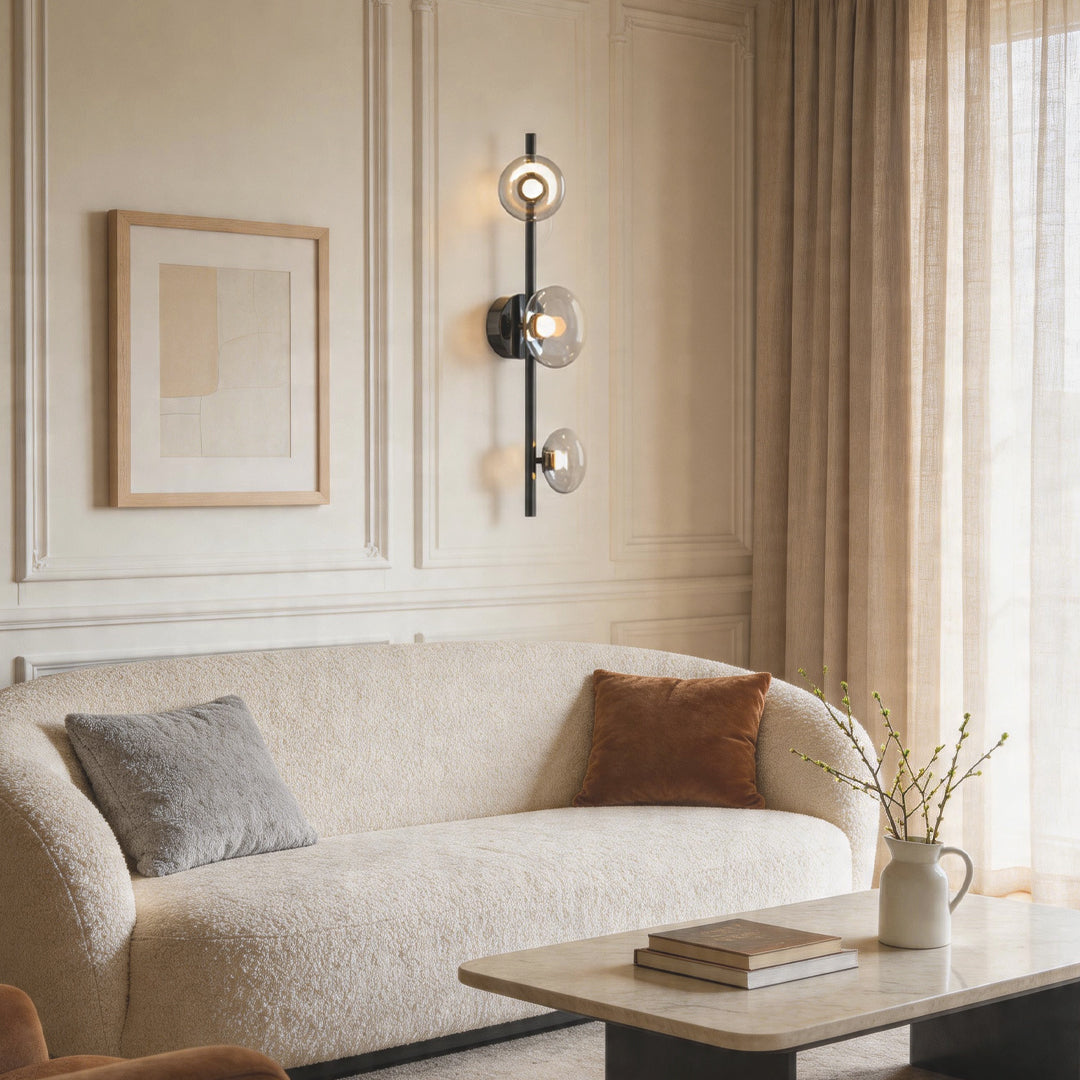 Multi light wall sconce illuminating a cozy seating area with textured wall panels and warm tones.