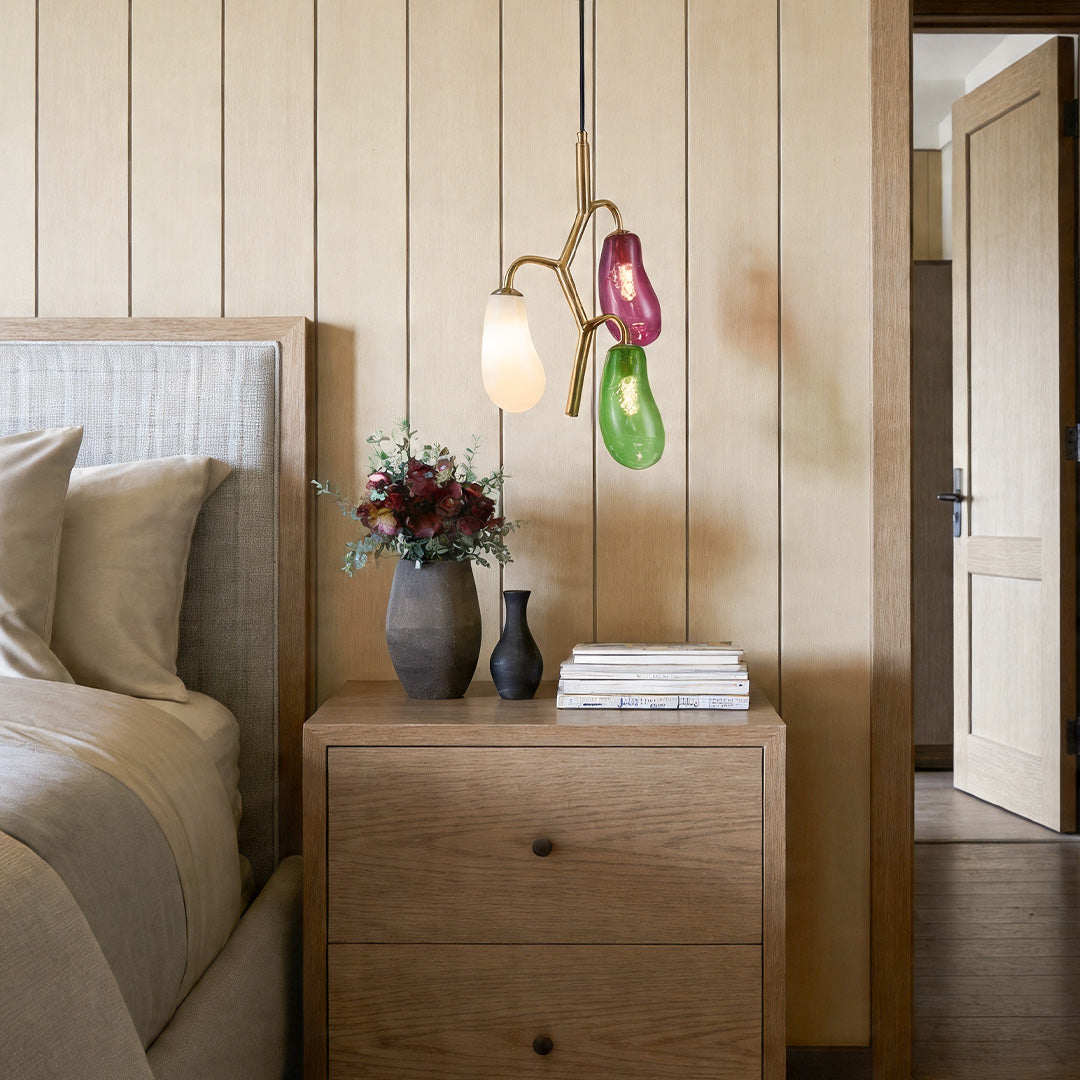 Multi pendant light fixture installed beside a bed in a cozy bedroom.