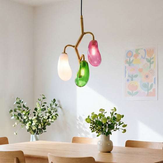 Multi pendant light fixture with colorful glass shades above a dining table.
