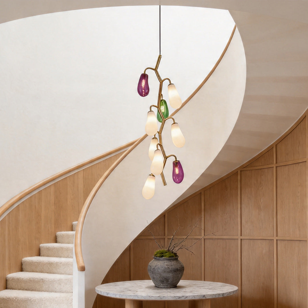 Modern multi pendant light fixture hanging in a curved staircase space.
