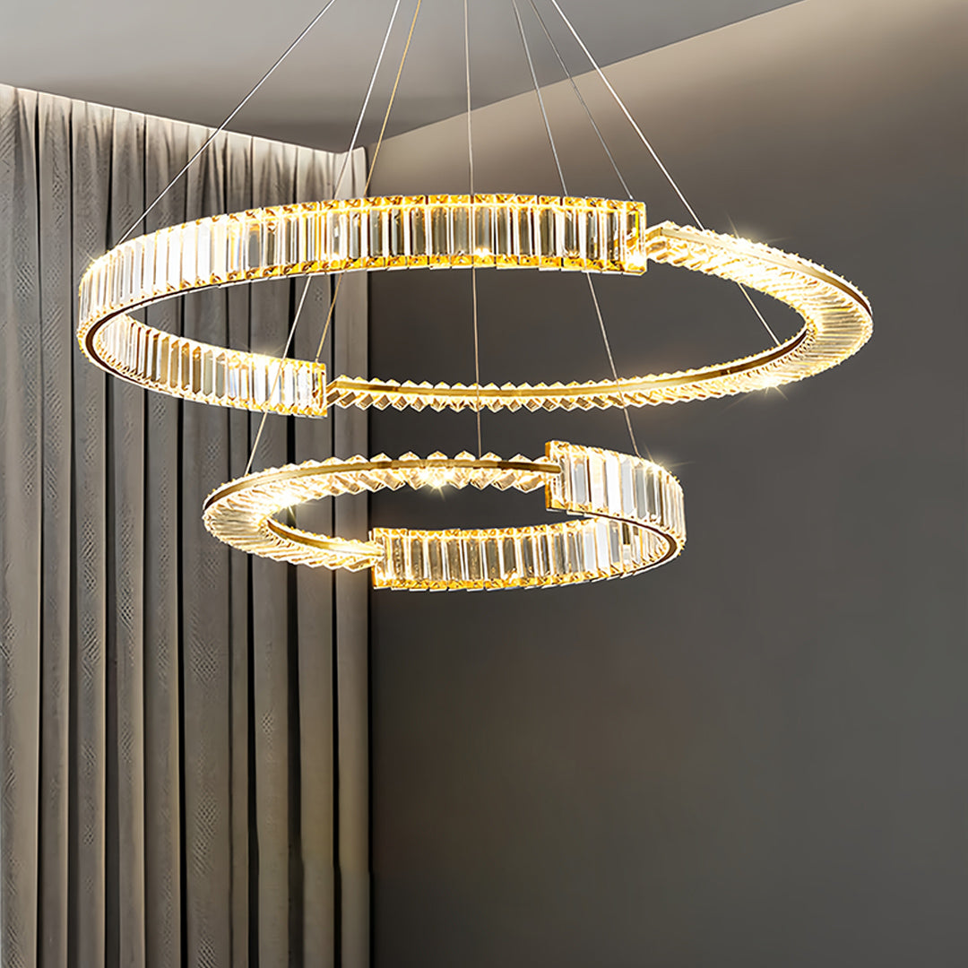 Multi-ring gold crystal chandelier creating dramatic lighting effects in modern space