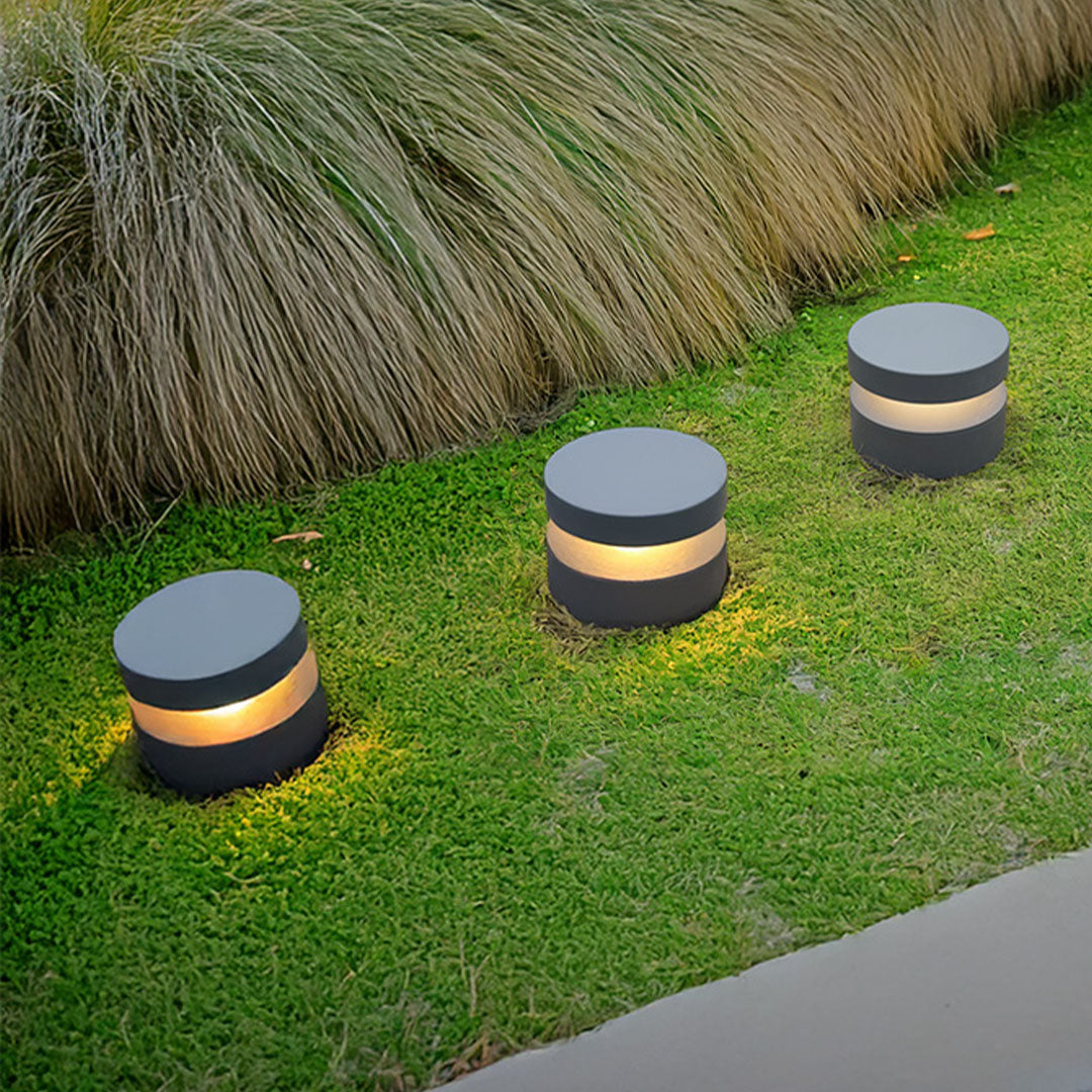 Multiple 110v landscape lights creating beautiful illumination pattern across manicured lawn area