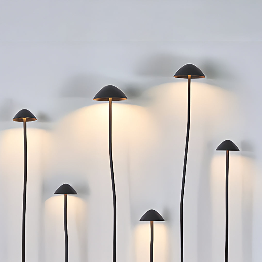 Multiple black mushroom garden lights arranged in artistic display showcasing versatile outdoor lighting design options
