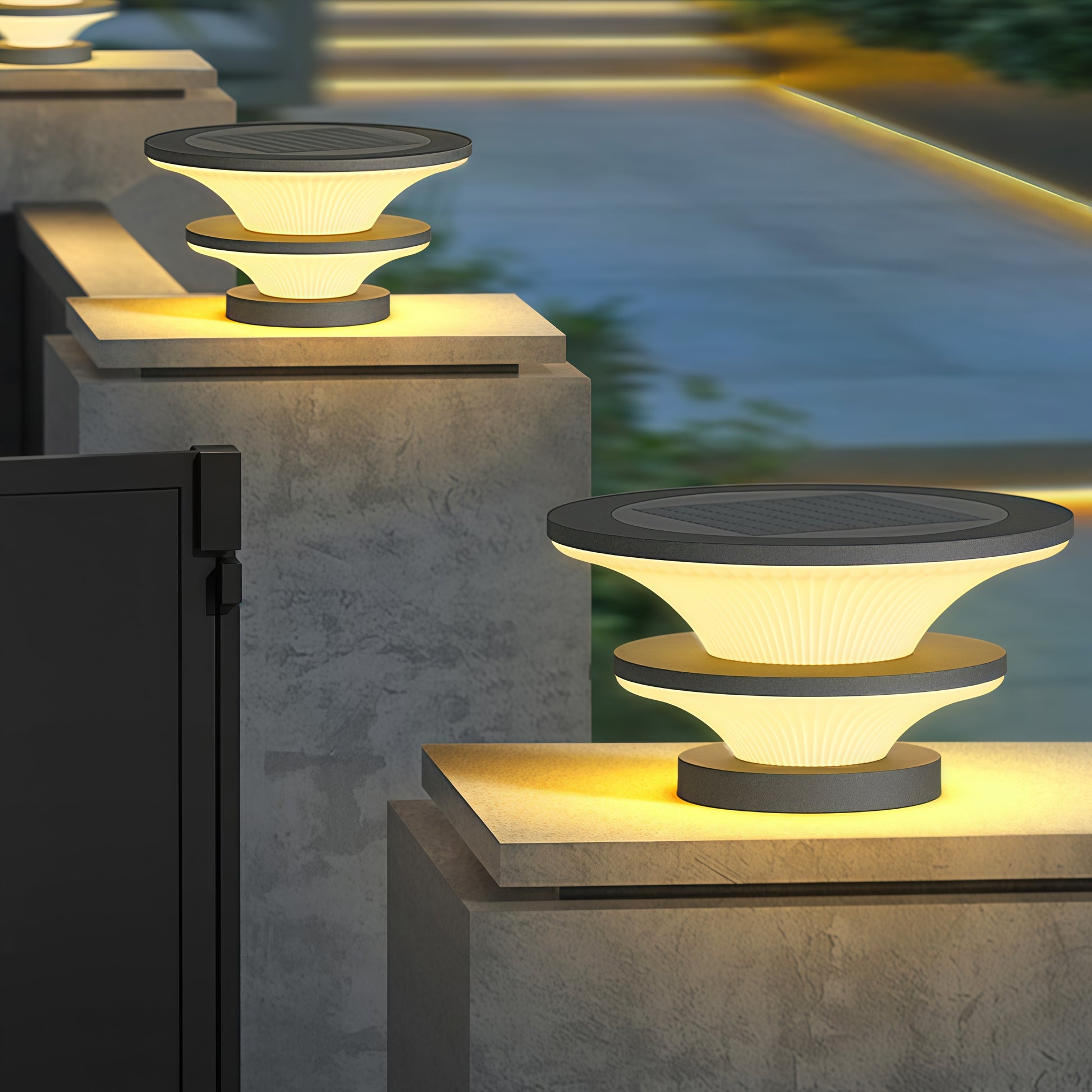 Multiple concrete pillar USB rechargeable table lamps creating dramatic evening lighting on outdoor terrace