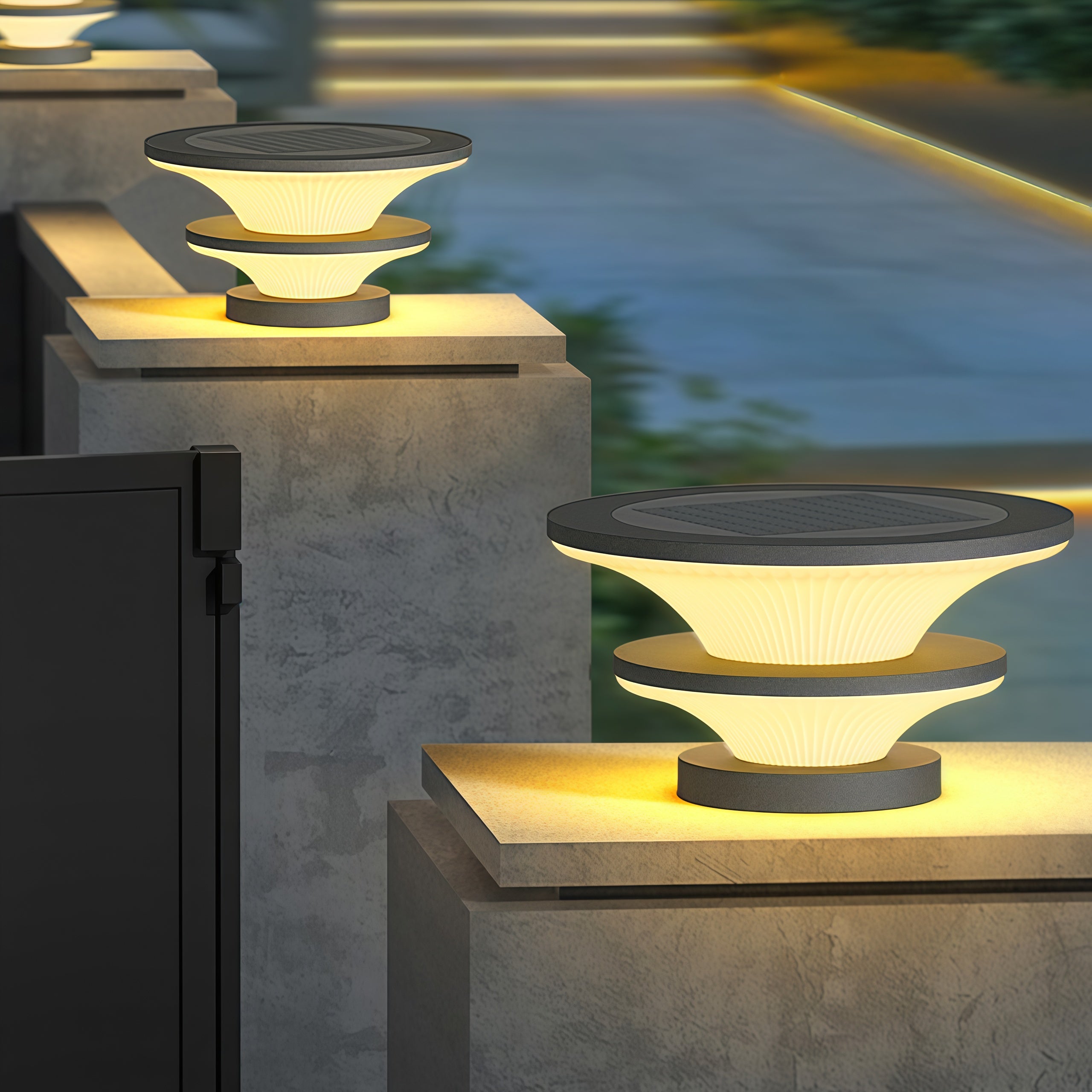 Multiple concrete pillar USB rechargeable table lamps creating dramatic evening lighting on outdoor terrace
