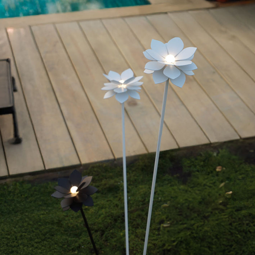 Multiple white flower landscape garden lights installed on wooden deck creating charming outdoor ambiance