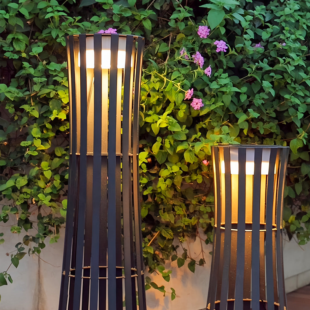 Multiple large outdoor black lanterns suspended along a long wooden archway, creating a rustic, illuminated pathway.