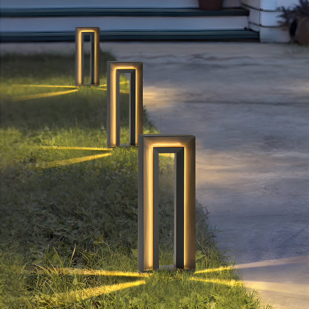 Multiple LED outdoor path lights creating warm golden illumination along modern walkway for safe nighttime navigation