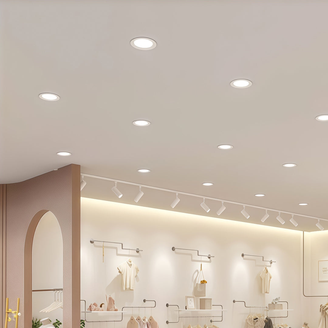 Multiple LED recessed downlights providing even lighting in bright commercial space with pink accents