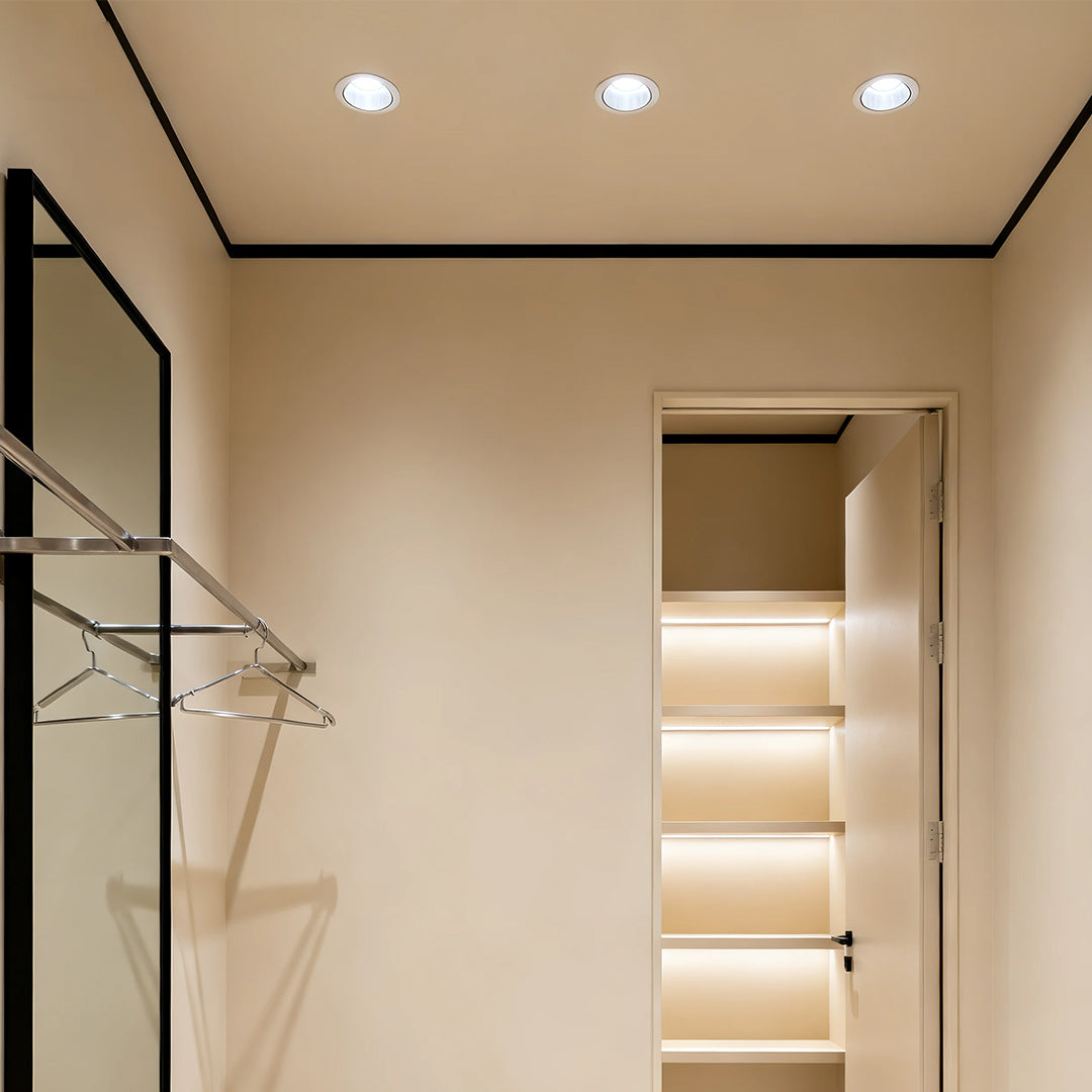 Multiple LED recessed spotlights brightening modern hallway with illuminated stair treads and glass partition