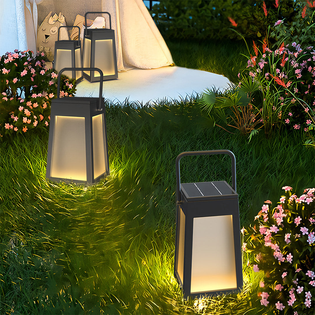 Multiple modern camping lantern fixtures scattered on grass in a garden setting, creating soft, tent-side illumination.